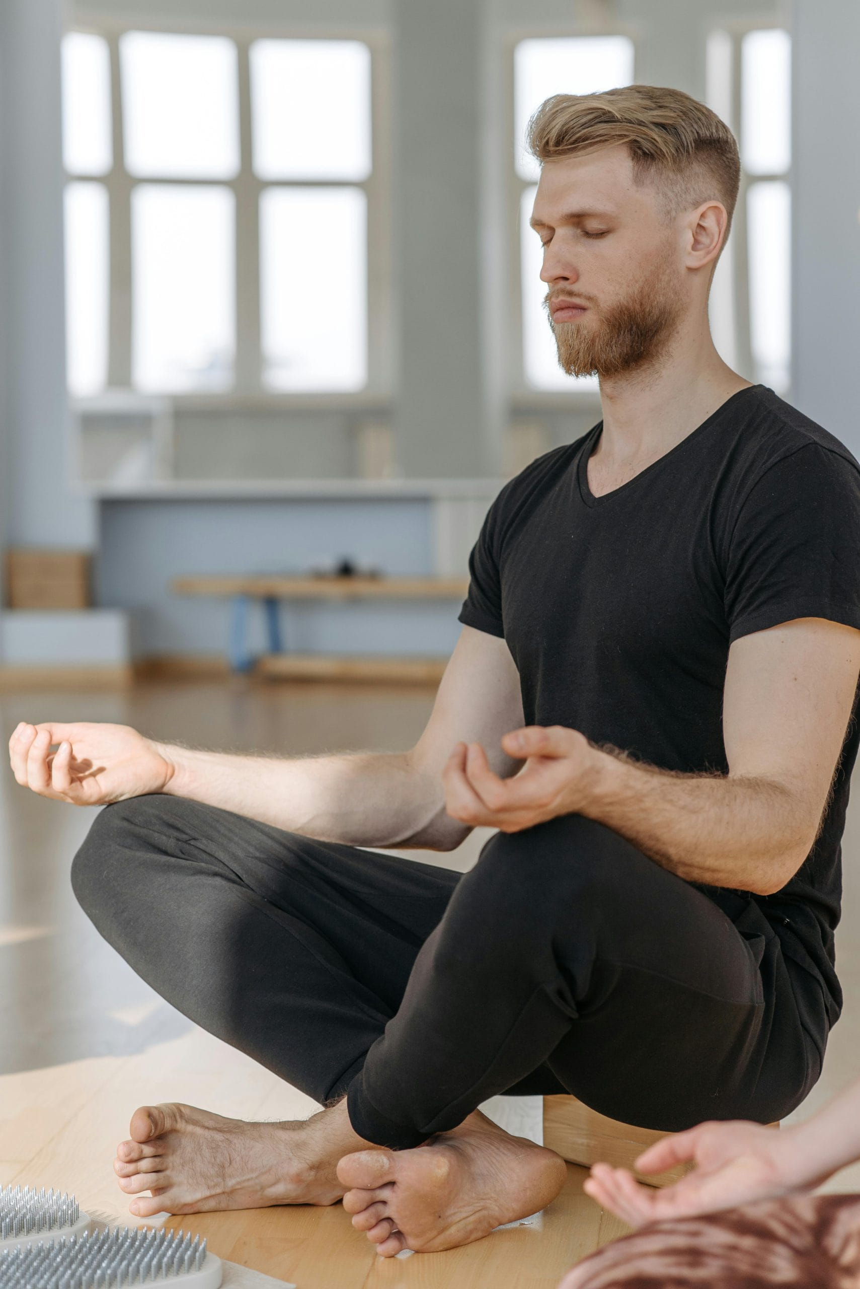 Calm adult man practicing meditation indoors, embracing peace and mindfulness.